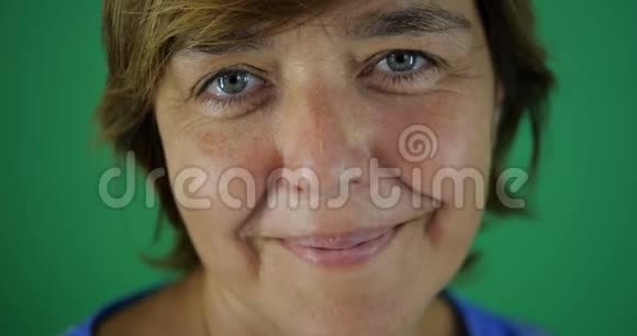 4K留着短发的中年妇女在绿色上眨眼微笑视频的预览图