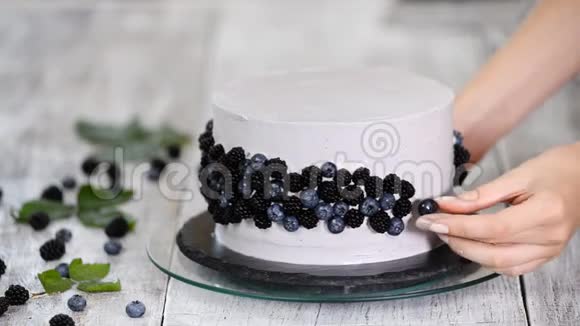 面包师在蛋糕上加入蓝莓和黑莓现代欧洲蛋糕糕点视频的预览图