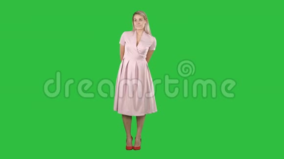 时尚打击年轻美丽的女性模特在绿色屏幕上摆着粉红色裙子的肖像ChromaKey视频的预览图
