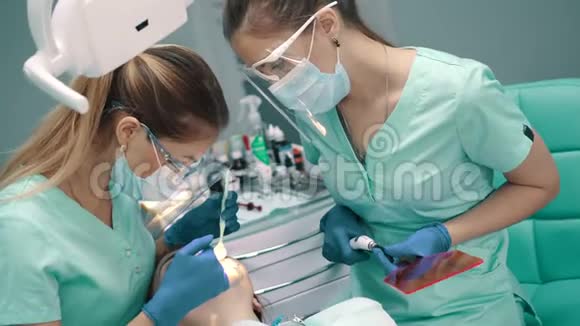 有助理的女牙医进行牙齿美白手术视频的预览图
