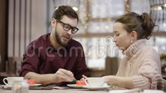 一个年轻人正在餐馆里用勺子喂妻子吃蛋糕视频的预览图