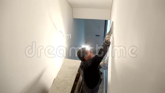 家庭装修工人带手套用砂光机工作表面光滑视频的预览图