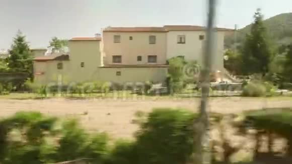田野森林和有建筑物的村庄加泰罗尼亚移动列车窗口视图视频的预览图