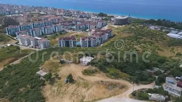 从空中俯瞰希腊沿海城市艺术许多建筑和房屋建在蓝色前面的丘陵地区视频的预览图