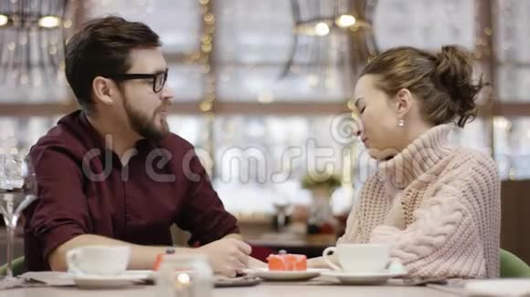 一个成年人坐在餐馆里给他的妻子送他从服务员那里得到的花她吻了他视频的预览图