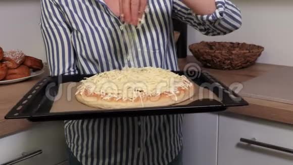 女人拿着奶酪在披萨上洒上奶酪视频的预览图