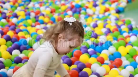 快乐的童女玩着五彩气球躲在操场上视频的预览图