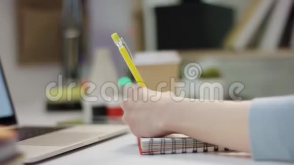 年轻女子在笔记本电脑前写着视频的预览图