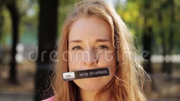 可爱的年轻女人留着长发嘴上挂着名牌看着相机视频的预览图
