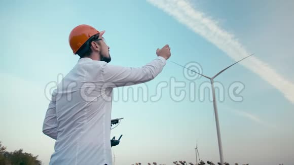 戴着橙色防护头盔和护目镜的白种人工程师驾驶着智能四翼飞机视频的预览图