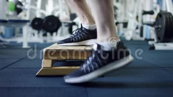 成年男子在健身房的台阶板上锻炼侧面轮廓拍摄视频的预览图