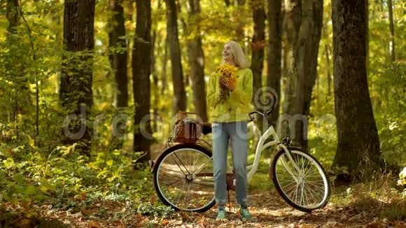 滑稽的表情和疯狂的人秋天快乐的女孩和快乐无忧无虑的女人带着花的复古自行车的秋女视频的预览图