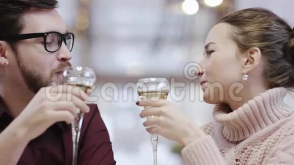 男人和女人在餐馆里拿着一杯香槟说话近距离拍摄眼镜视频的预览图