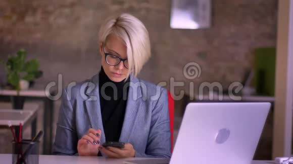 中年短发女商人戴着智能手机工作眼镜的肖像在办公室里微笑着拍摄视频的预览图