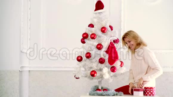 用红球装饰圣诞树假日和人的概念快乐妈妈在家装饰圣诞树视频的预览图