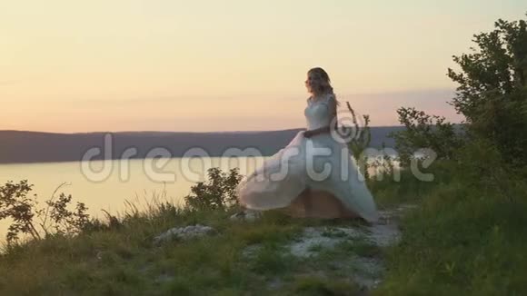日落时在海滩上的情侣女孩跳进她男朋友的怀里慢动作视频的预览图