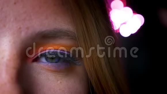 蓝眼睛的金发女性的特写半肖像粉红色的灯光背景上鲜艳的化妆视频的预览图