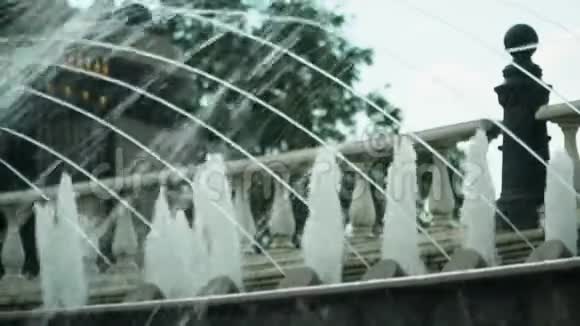 喷泉的细喷流在前景中以弧形连续流动视频的预览图