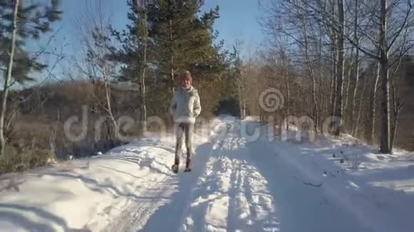 穿暖和夹克的空中女子喜欢在古老的冬林里徒步旅行视频的预览图