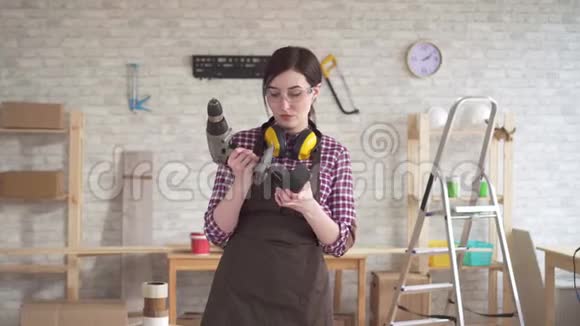 一位有着电钻的年轻木工女画像视频的预览图