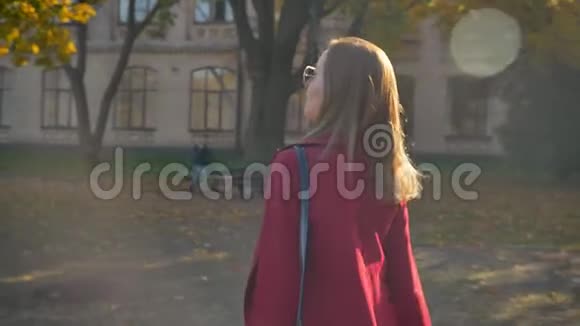 年轻迷人的女性学生自信地走出大学在阳光明媚的日子里整理头发微笑着视频的预览图