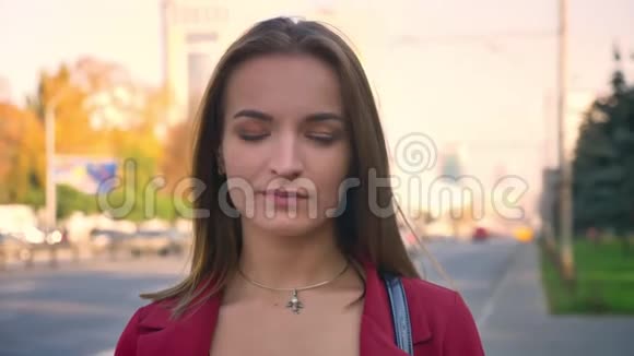 年轻迷人的女性特写镜头站在城市的街道上用她的眼睛表达谴责视频的预览图