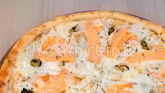 一半切片披萨与海鲜和奶酪在木板上近距离观看视频的预览图