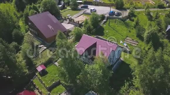 夏季村住宅小区及房屋的鸟瞰图剪辑小屋明亮的粉红色屋顶的俯视图视频的预览图
