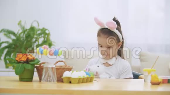瘦小的女孩在做手势拉着一只柔软的兔子该睡觉了视频的预览图