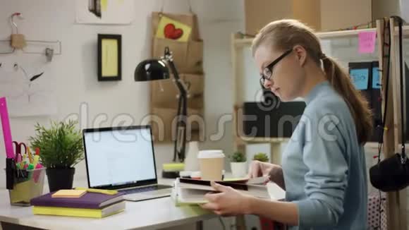 一个年轻漂亮的女孩一个个桌子看一本书视频的预览图