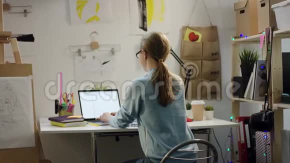 年轻的设计师在她的笔记本电脑上工作视频的预览图