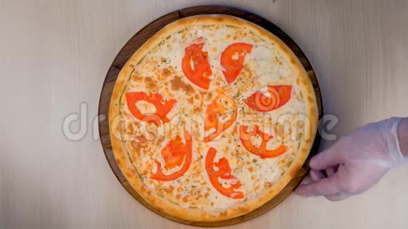 厨师在木板上切比萨饼上面有西红柿和奶酪俯视图手特写视频的预览图