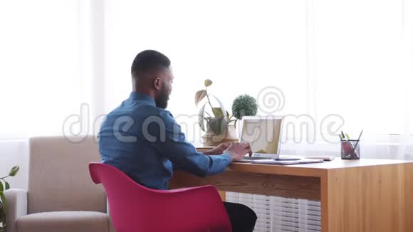 商人使用笔记本电脑靠在办公椅上视频的预览图
