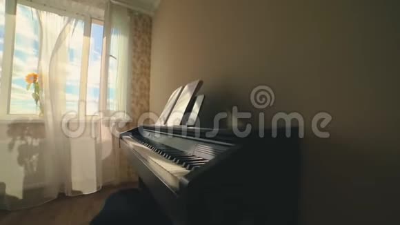 风中吹着的白色窗帘花瓶里的向日葵房间里的电动钢琴视频的预览图