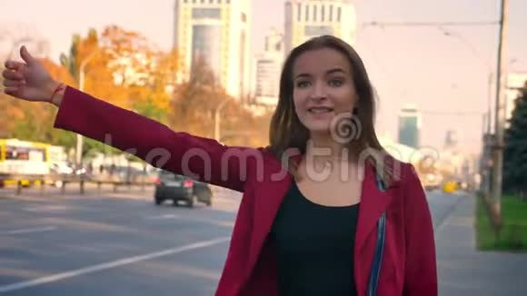 年轻有魅力的女性站在人行道上找车在城市里没能搭车很失望视频的预览图