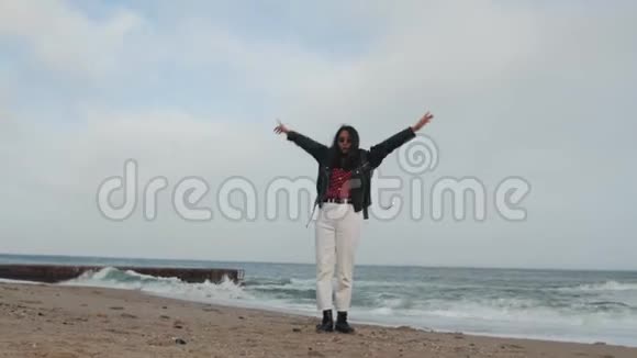 一个穿着皮夹克戴着太阳镜在海面上旋转的女孩视频的预览图