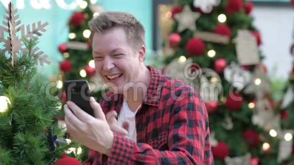 快乐的年轻人视频呼唤和拍摄圣诞树户外视频的预览图