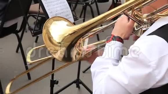 男子音乐家演奏长号在市政管弦乐队演奏露天音乐会视频的预览图