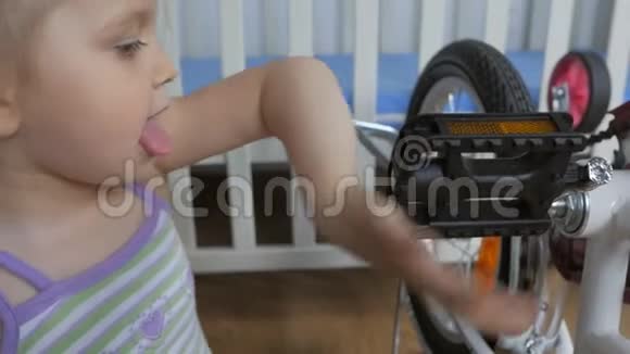 三岁的小女孩在托儿所里骑自行车视频的预览图