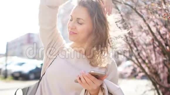 一个成熟女人手里拿着智能手机的春天肖像帮助妇女的技术网上购物视频的预览图