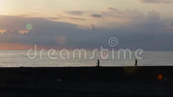 朋友在日落时沿着海滩散步视频的预览图