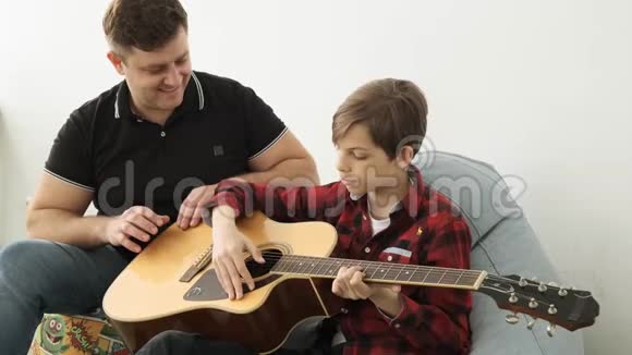 在学习如何在父亲和儿子之间演奏吉他方面的团结视频的预览图