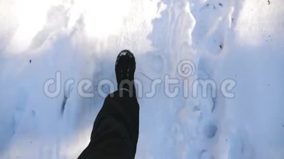 在雪道上行走的男性脚上的俯视图穿靴子的人在路上踩着洁白的雪无法辨认视频的预览图