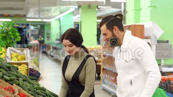 快乐的一对夫妇在杂货店或超市买胡椒和蔬菜视频的预览图