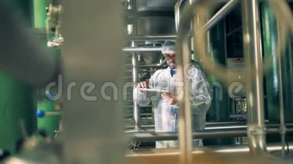 男工程师正站在酿酒厂的一个单位里操作平板电脑视频的预览图