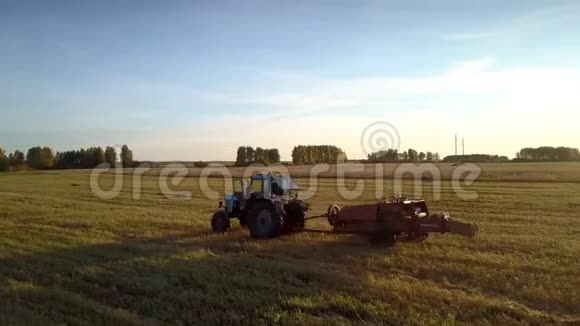 带现代方形打包机的拖拉机在日落时运行视频的预览图