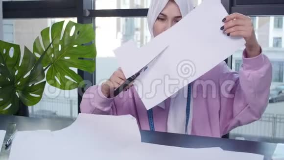 小企业和爱好概念穆斯林妇女时装设计师在裁缝店的桌子上钉纸图案视频的预览图