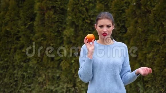 肖像年轻女人拿着橙色玩着它可爱的微笑视频的预览图