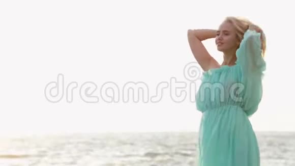 美丽的鞣制时尚性感女孩穿着迷人的裙子在海滩上摆姿势在她惊人的假期视频的预览图
