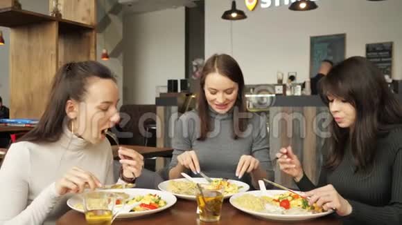 三个女朋友在咖啡馆里一起吃饭聊天享受他们的食物视频的预览图